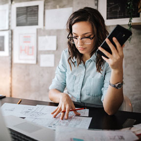 woman at desk with phone