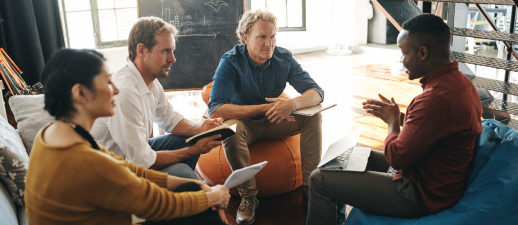 Four members of a corporate alumni network meeting in a casual atmosphere