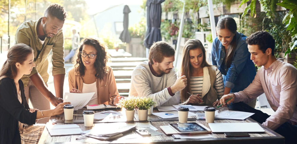 Cropped shot of a group of colleagues having a meeting outside at a cafe